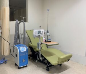 虎の門病院化学療法室（42床）　青い装置がPAXMAN頭皮冷却装置の本体です